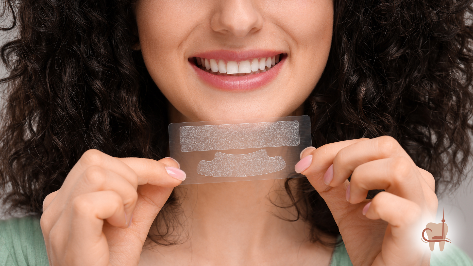Woman holding teeth whitening strips, smiling, preparing to use them.