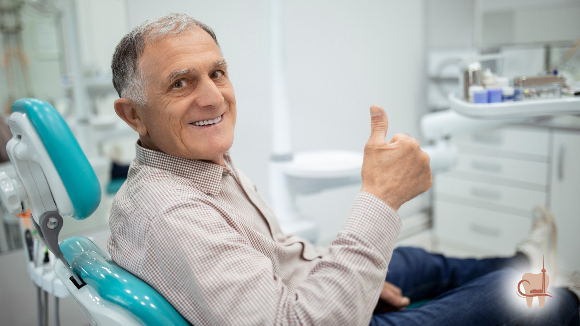 Smiling older man in dental chair giving thumbs up.