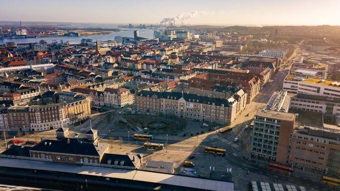 An aerial view of a city with a lot of buildings and a river in the background.