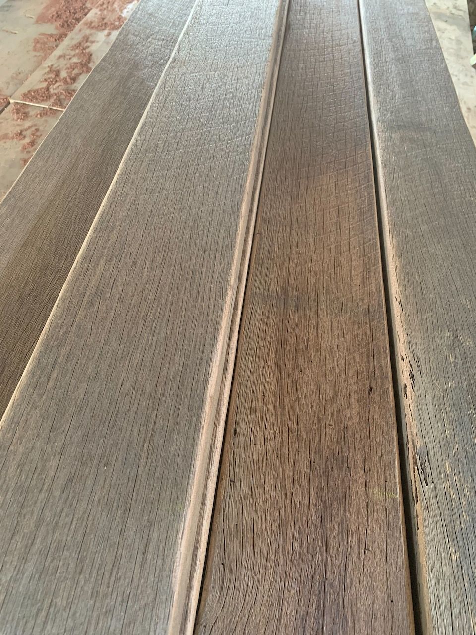 Close-up view of four dark brown wooden planks with straight edges.