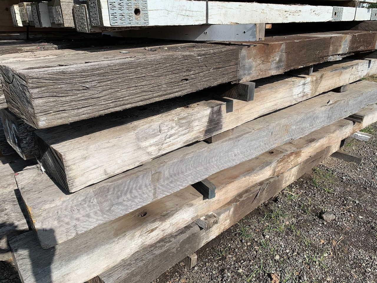 Stack of weathered, rectangular wooden beams.