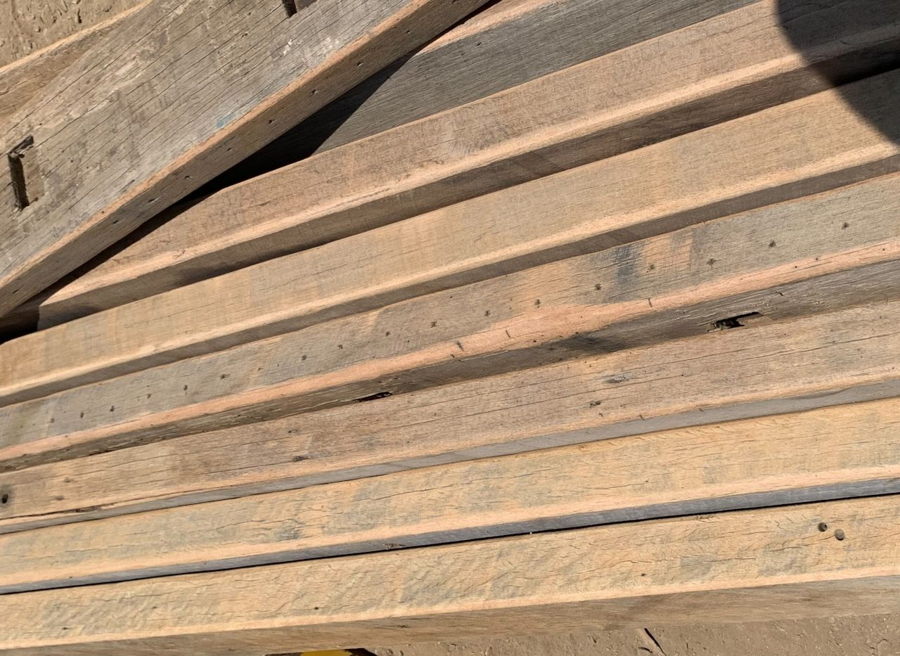 Pile of weathered, rectangular wood planks.