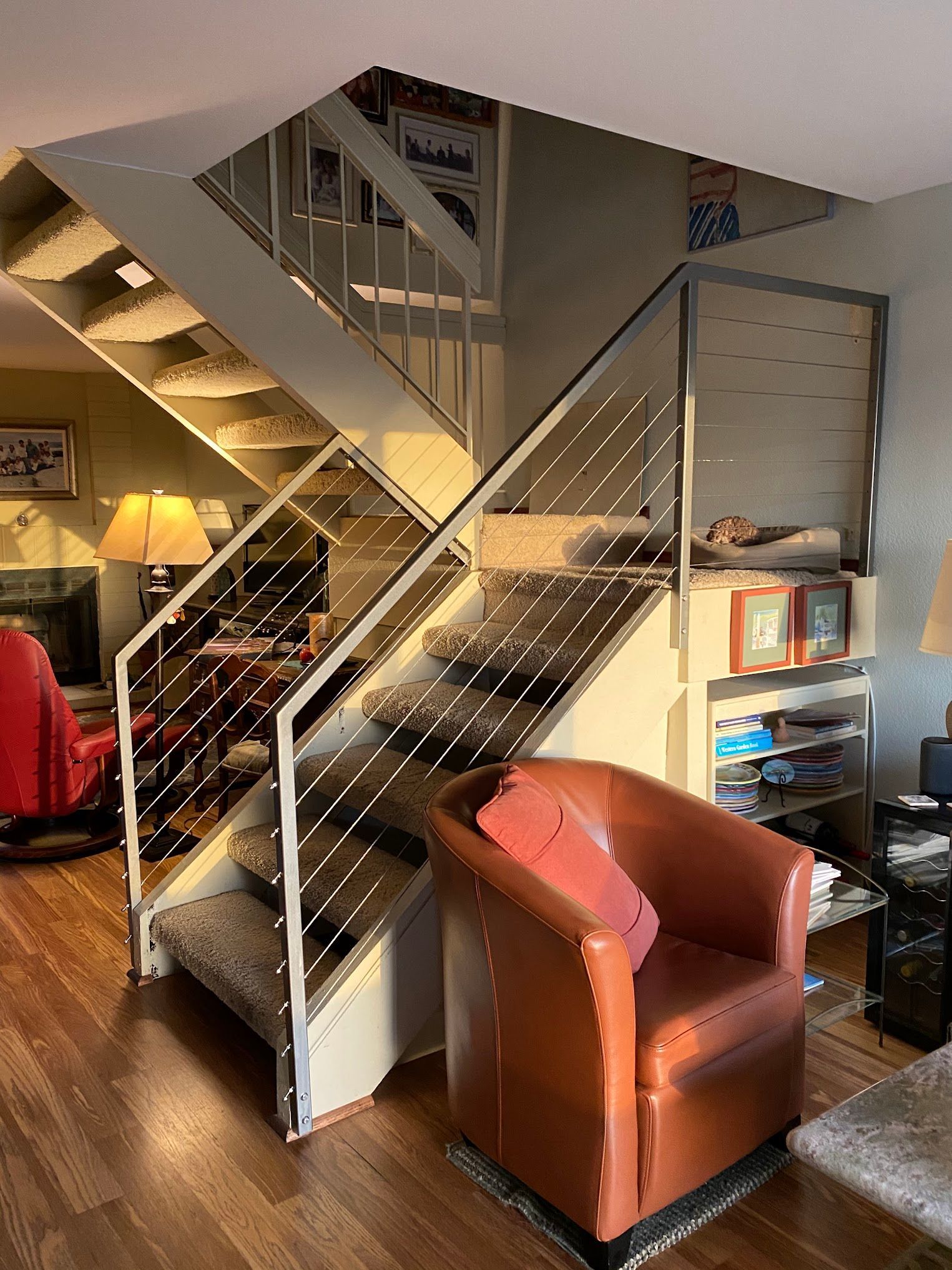 A living room with a staircase and a chair