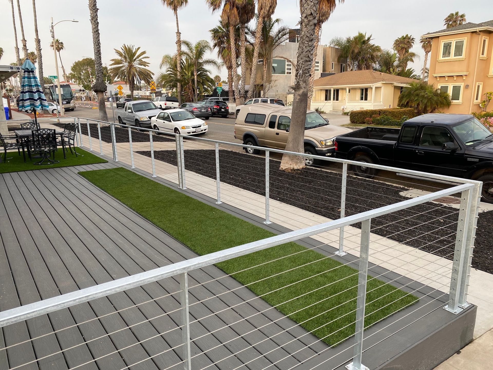 A fenced in area with a lot of cars parked on the side of the road.