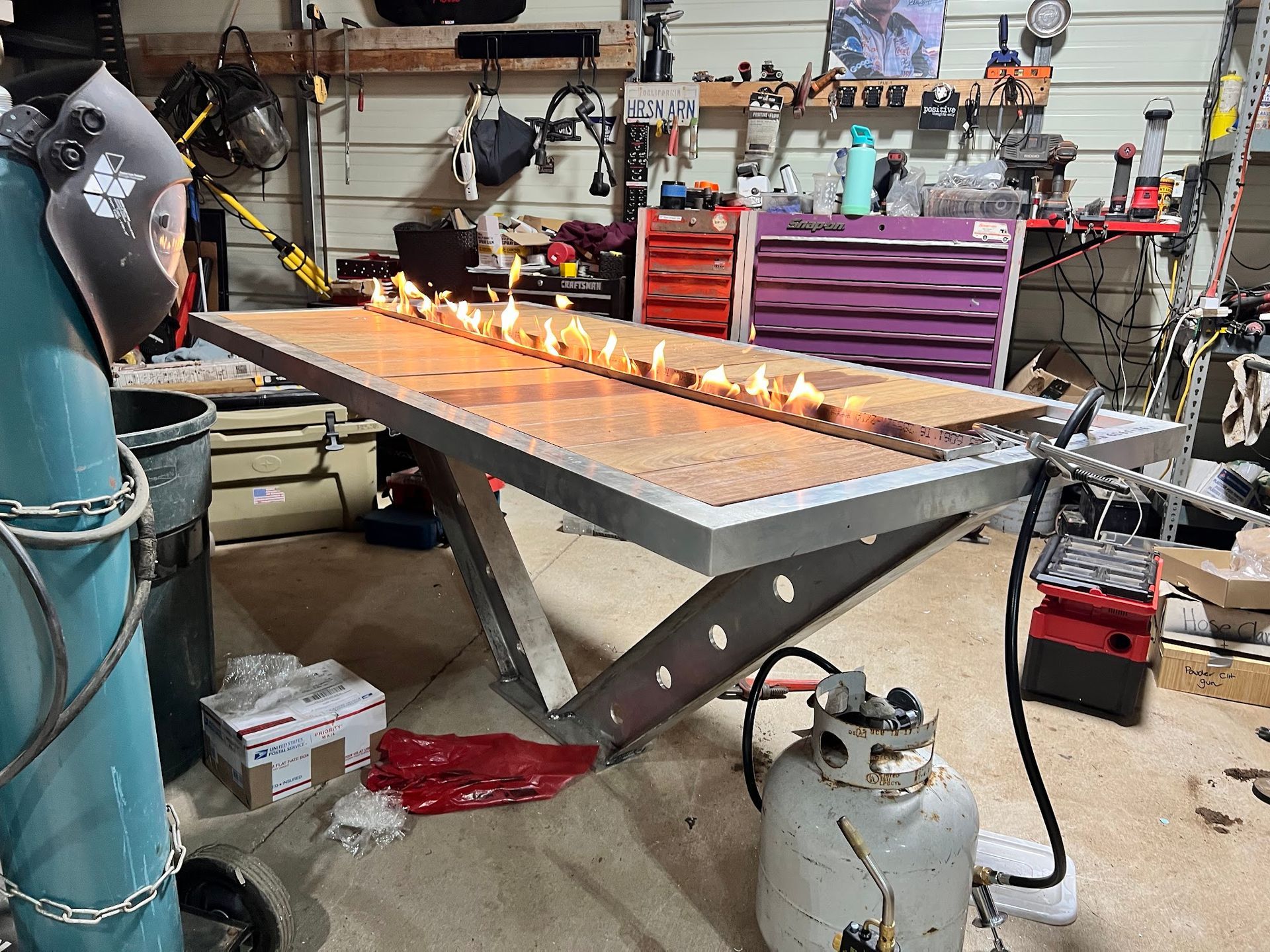 A table with a lot of candles on it in a garage.