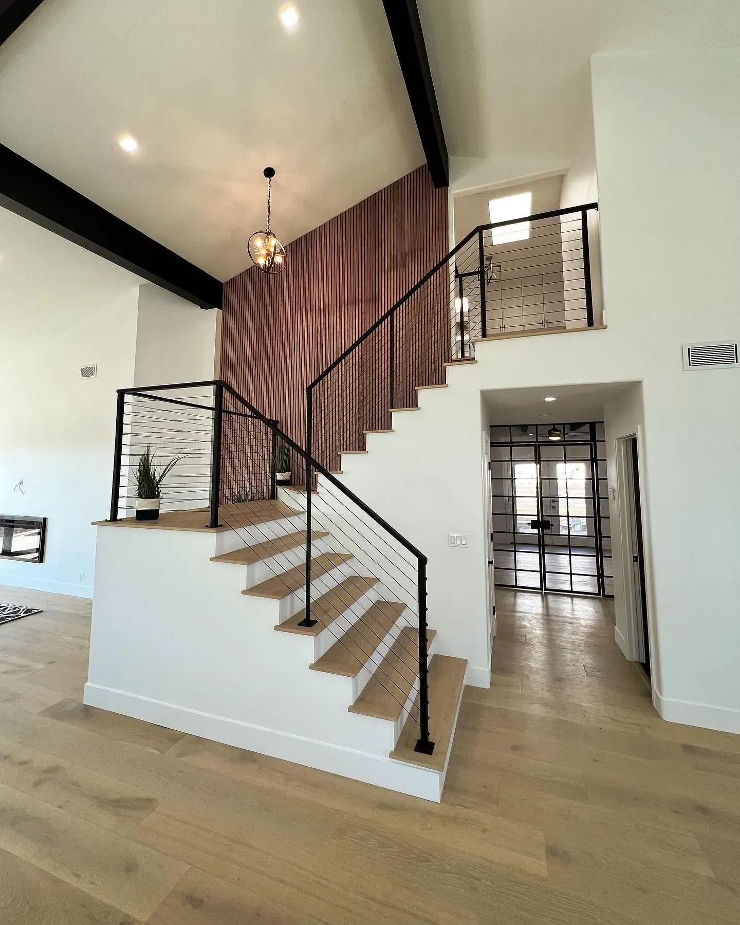 A staircase in a house with wooden steps and a metal railing