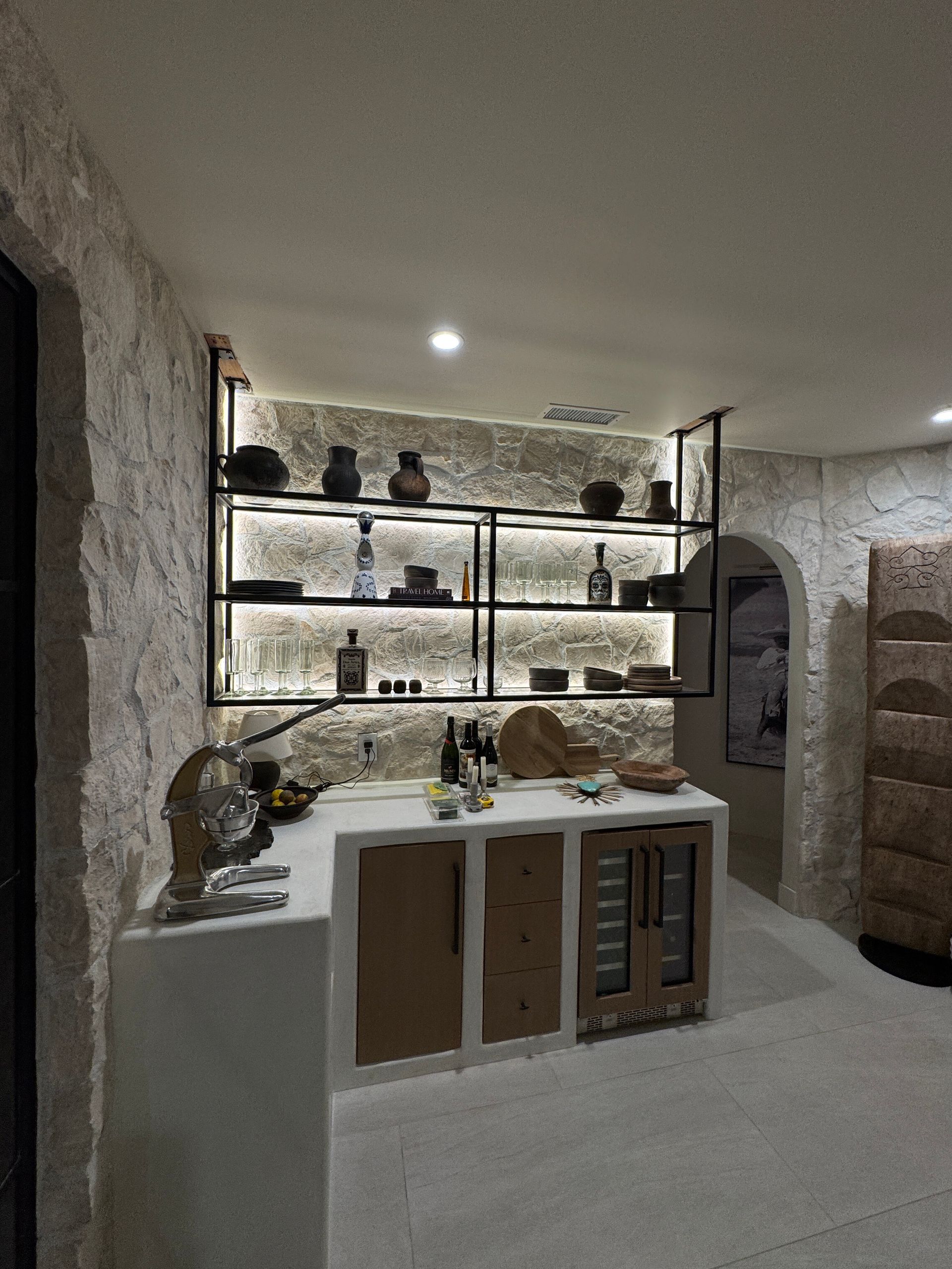 A room with a lot of shelves and a refrigerator.