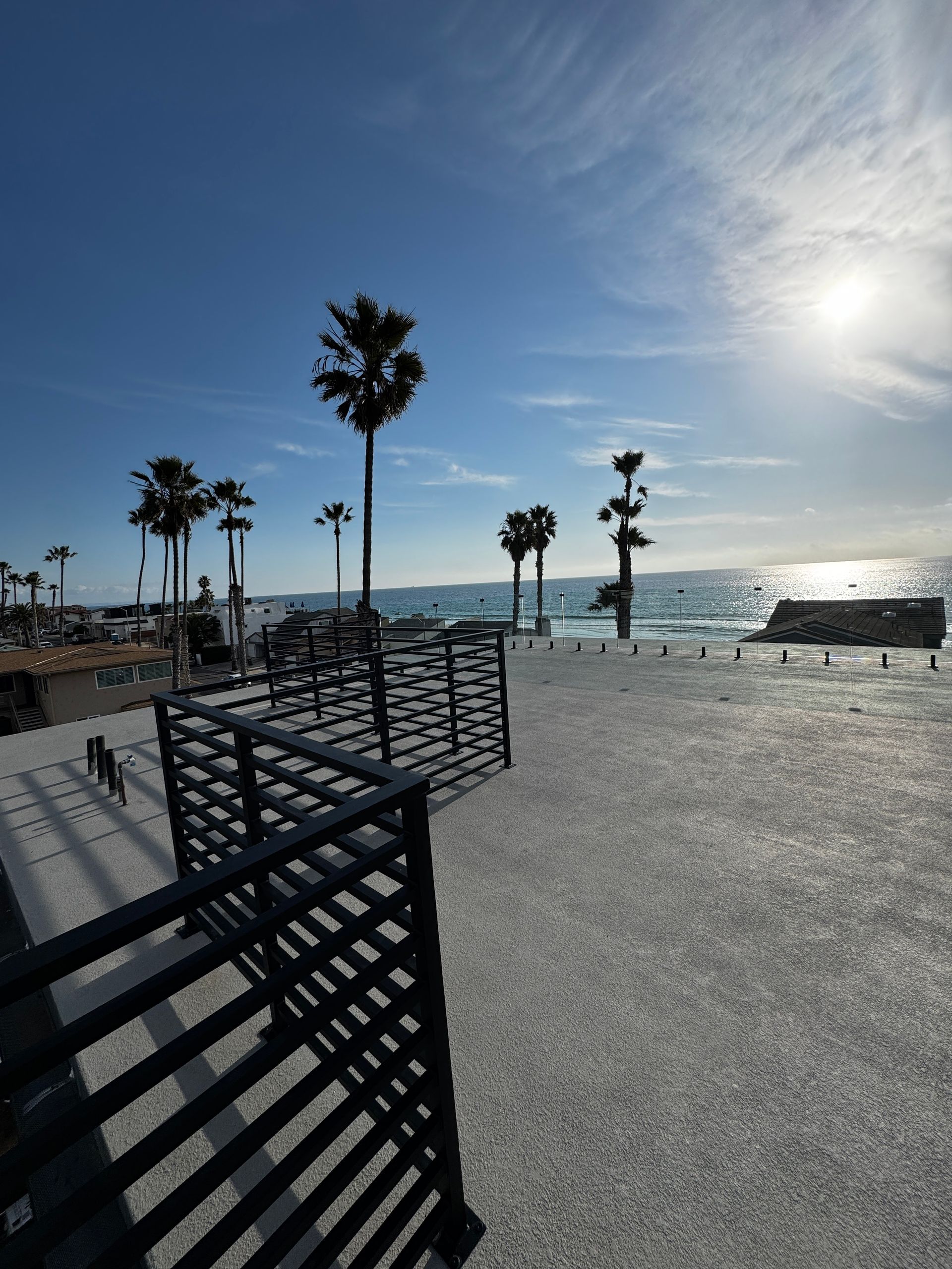 A beach with palm trees and a bench in the foreground