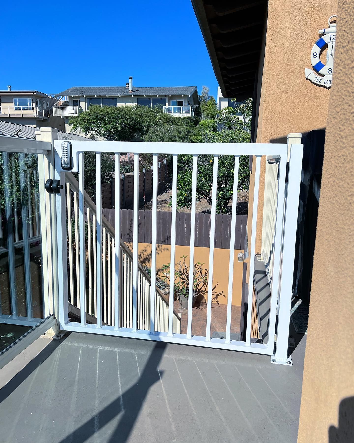 A white fence surrounds a balcony with stairs leading up to it.