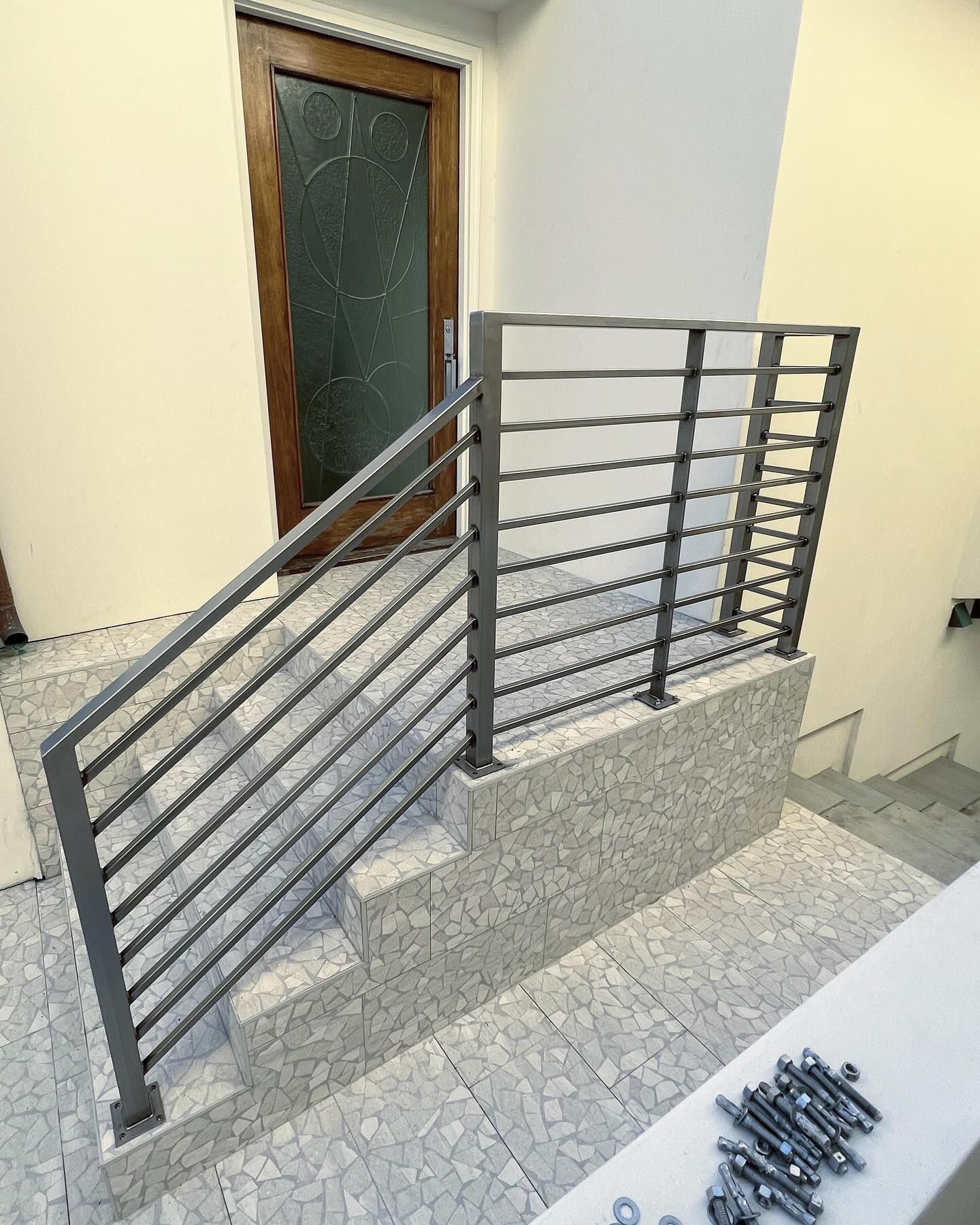 A staircase with a metal railing and a door.