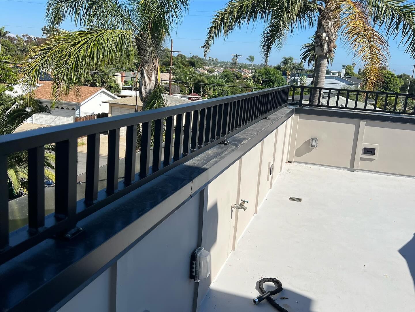 A balcony with a railing and a palm tree in the background