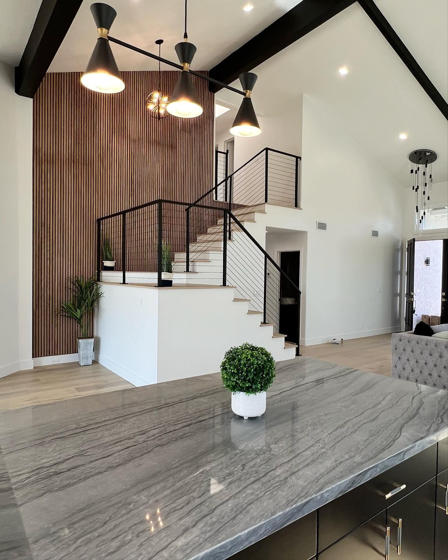 A kitchen counter with a plant on it in front of a staircase.