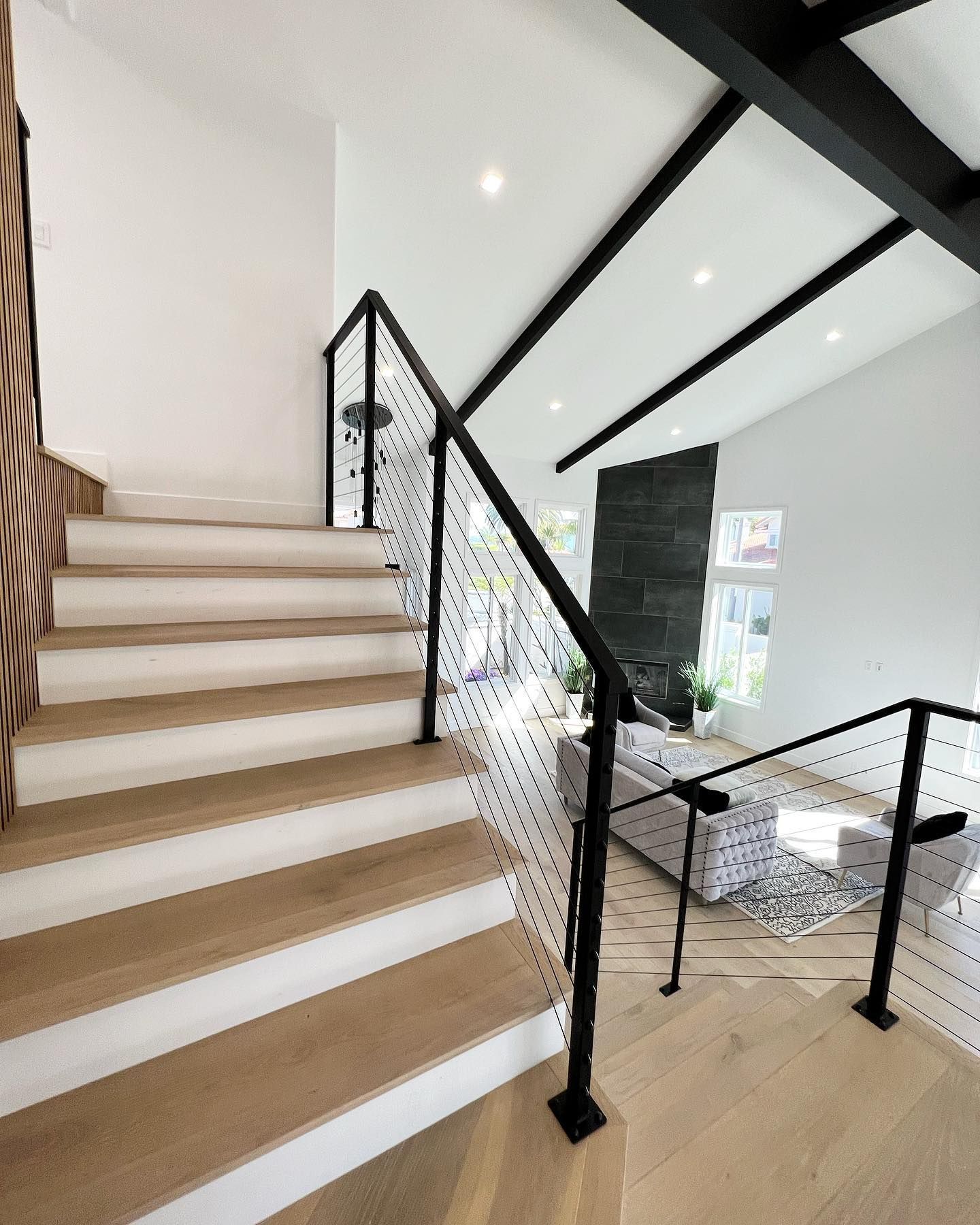 A staircase in a living room with a black railing