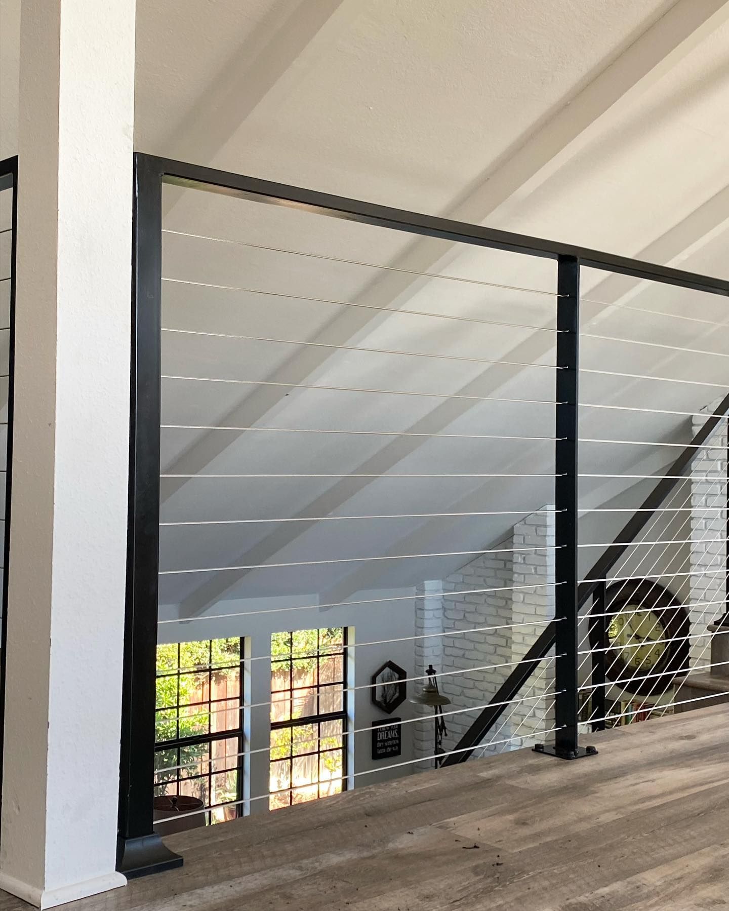 A staircase with a black railing and a wooden floor