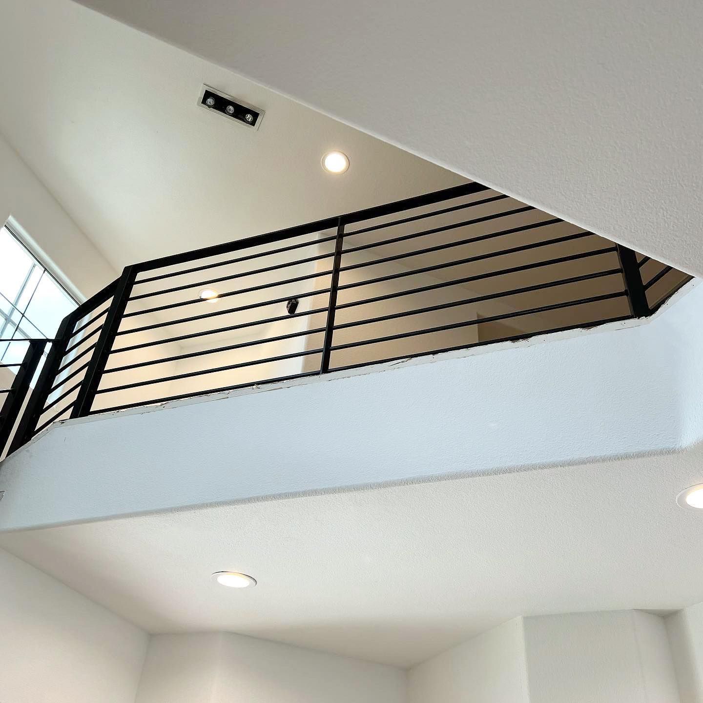 Looking up at a balcony with a black railing