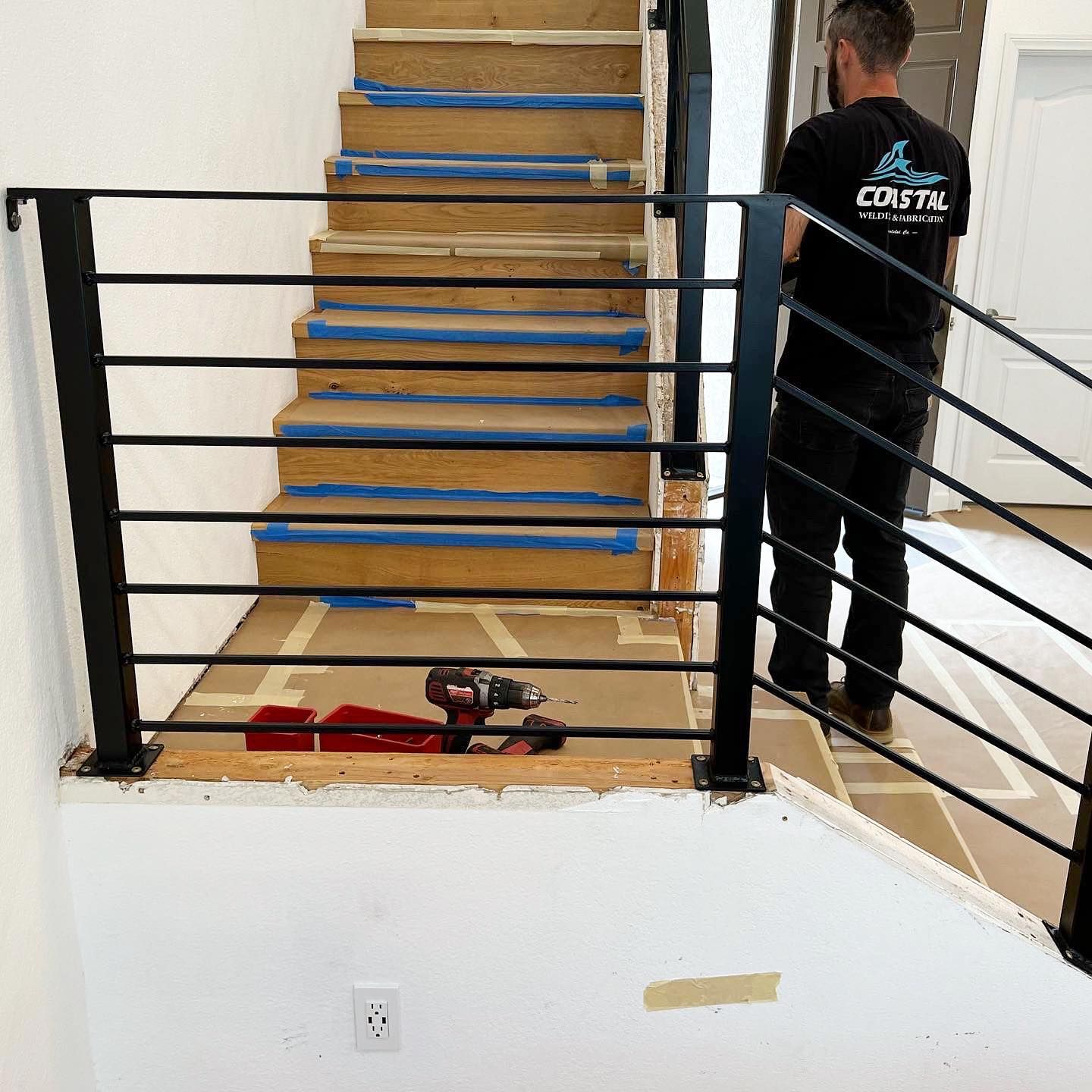 A man wearing a shirt that says coyote is standing next to a staircase