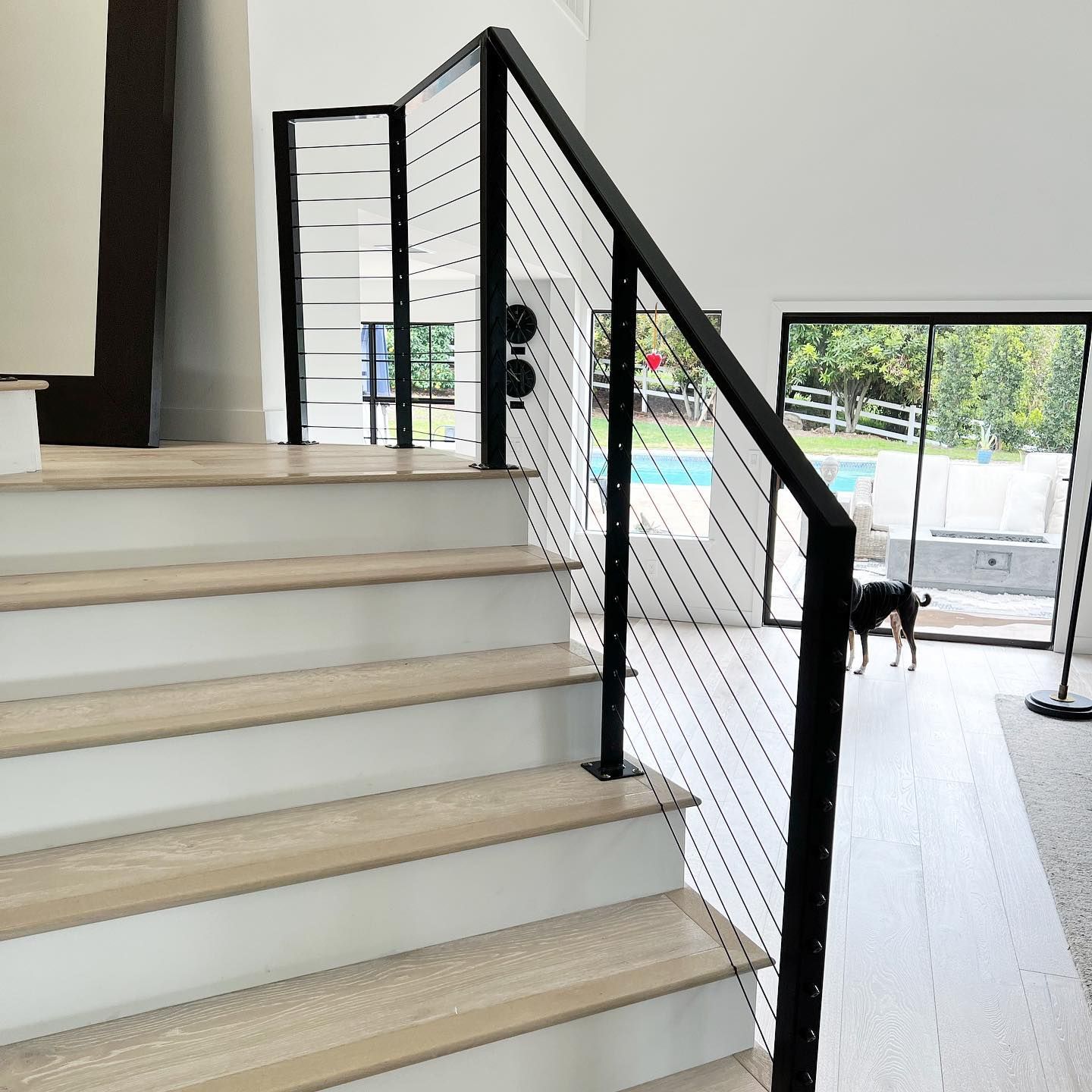 A staircase with a black railing and wooden steps in a house.