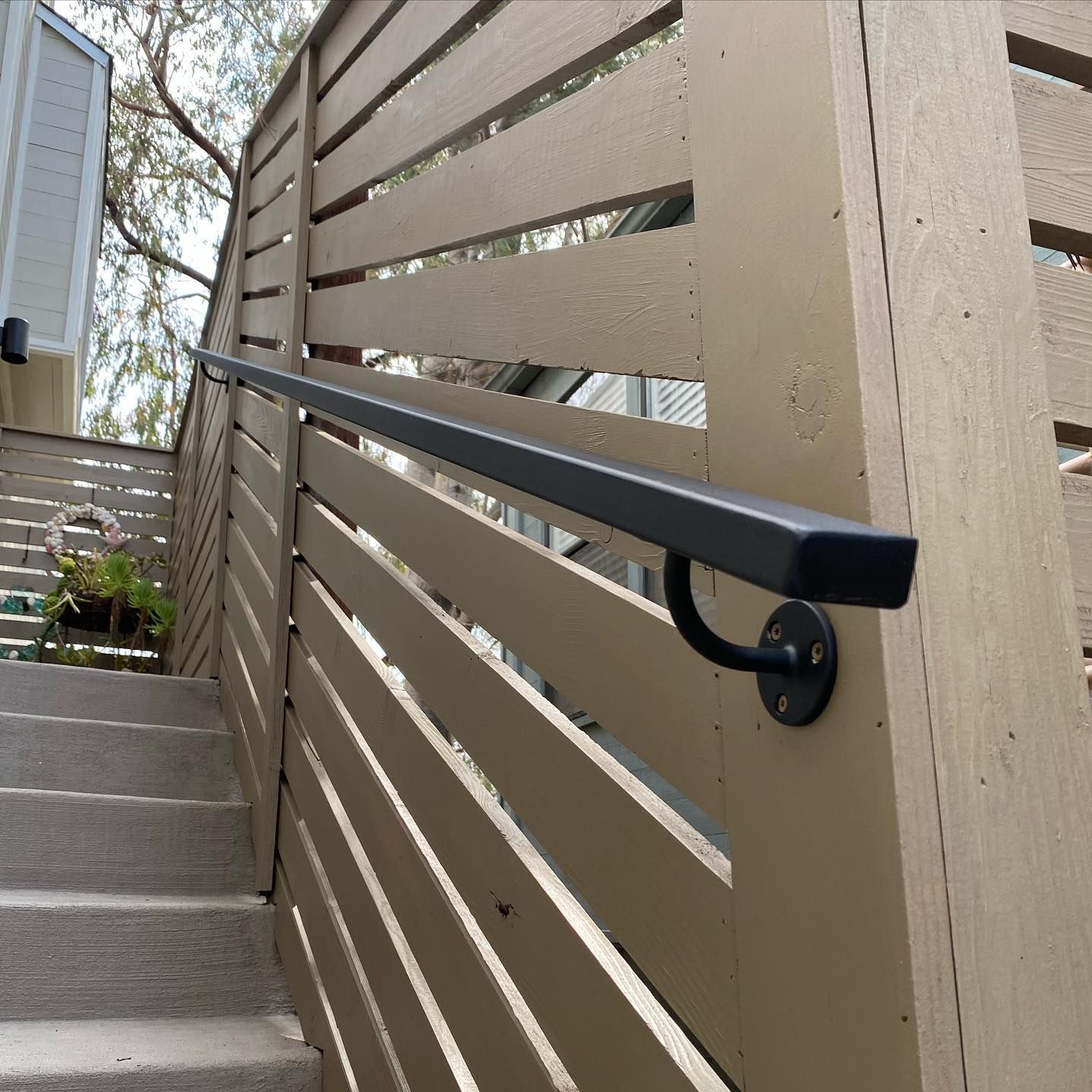 A wooden fence with a black railing on it