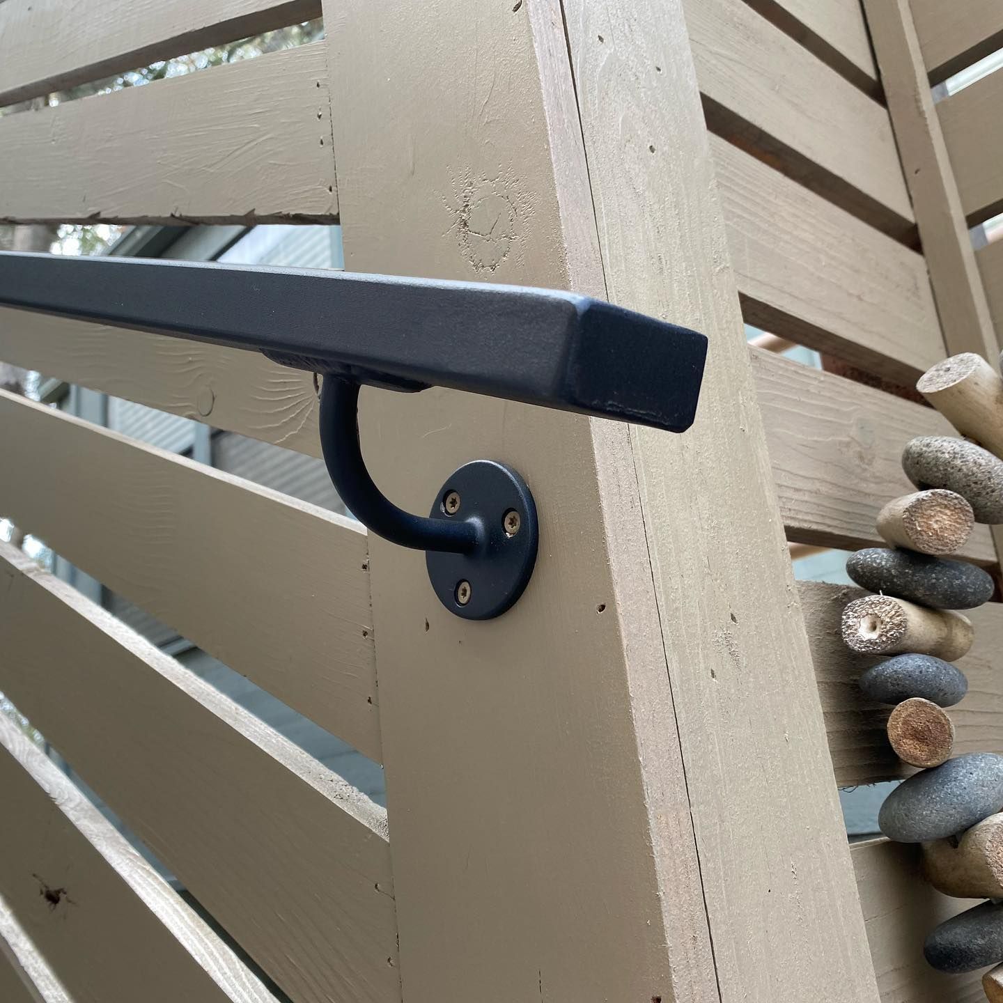 A hand rail is attached to a wooden fence