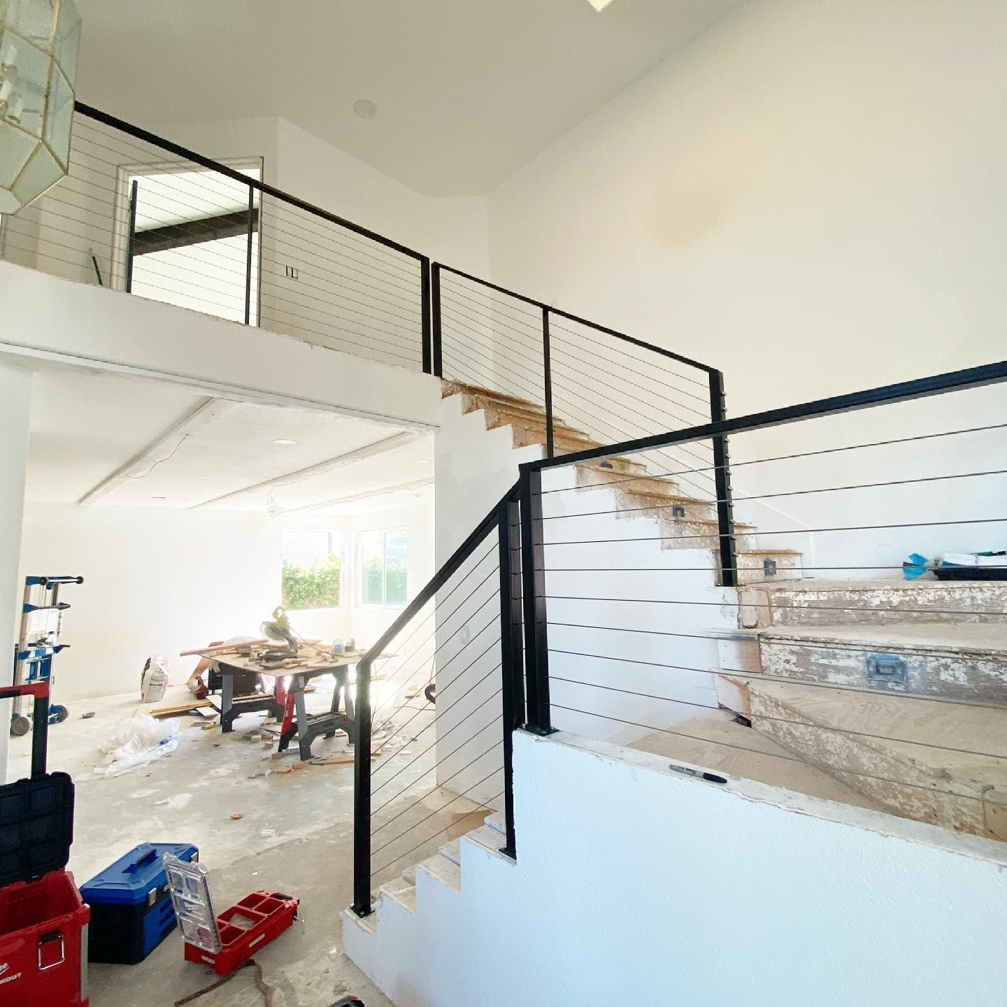 A staircase in a house under construction with a black railing