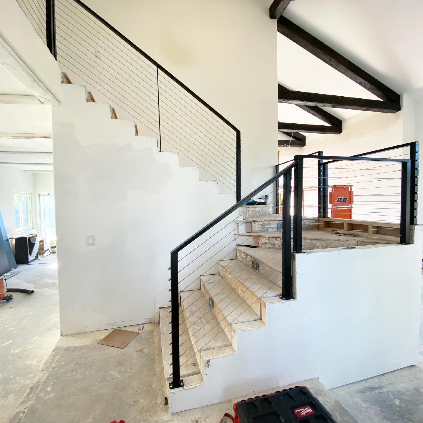 A staircase with a black railing is being built in a house