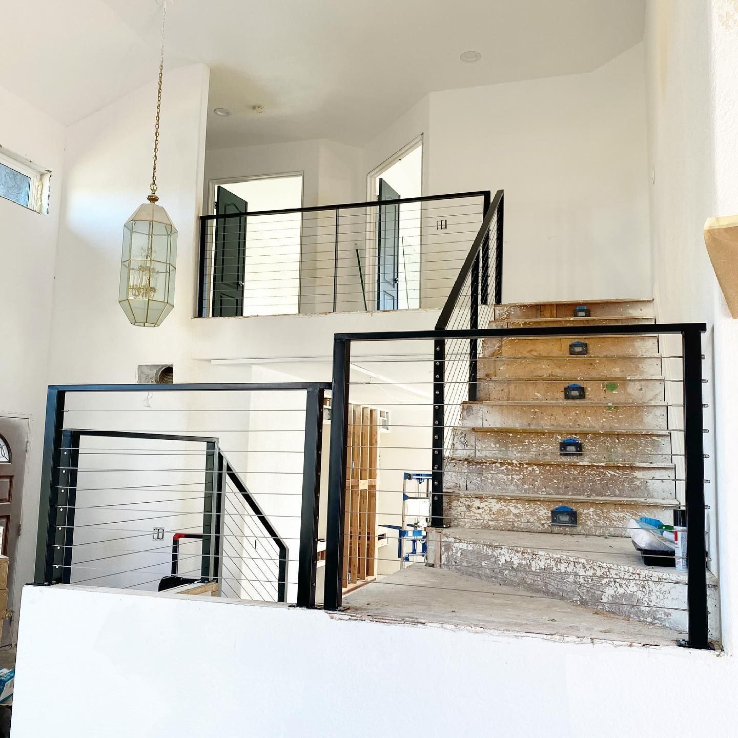 A staircase with a black railing is being built in a house.