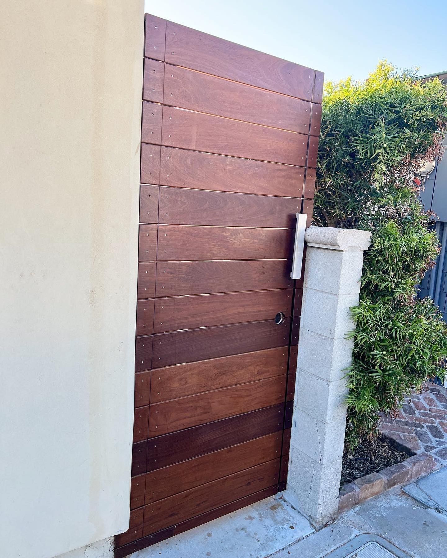 A wooden gate is sitting on the side of a building.