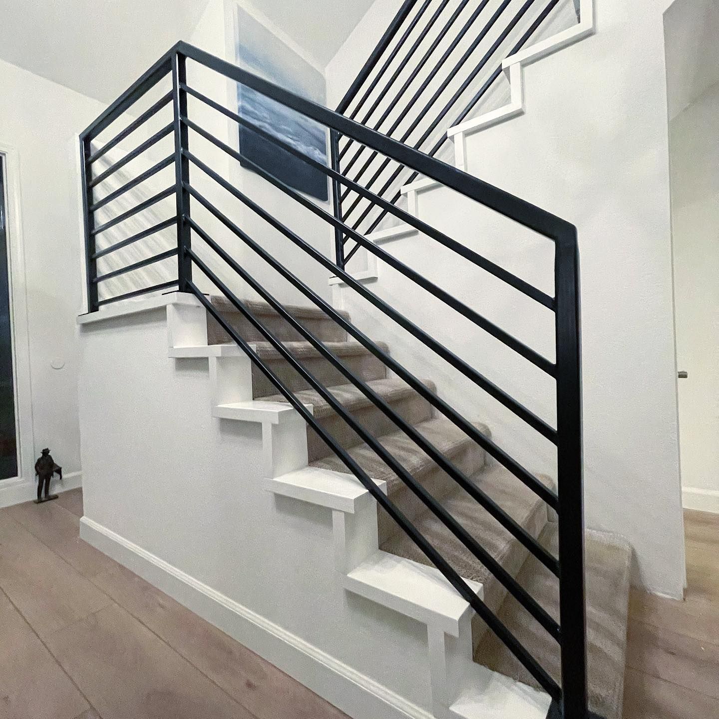 A staircase with a black railing and white steps
