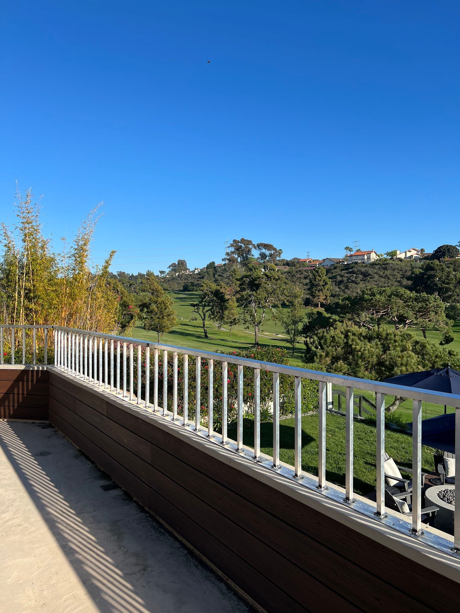 A view of a golf course from a balcony with a railing