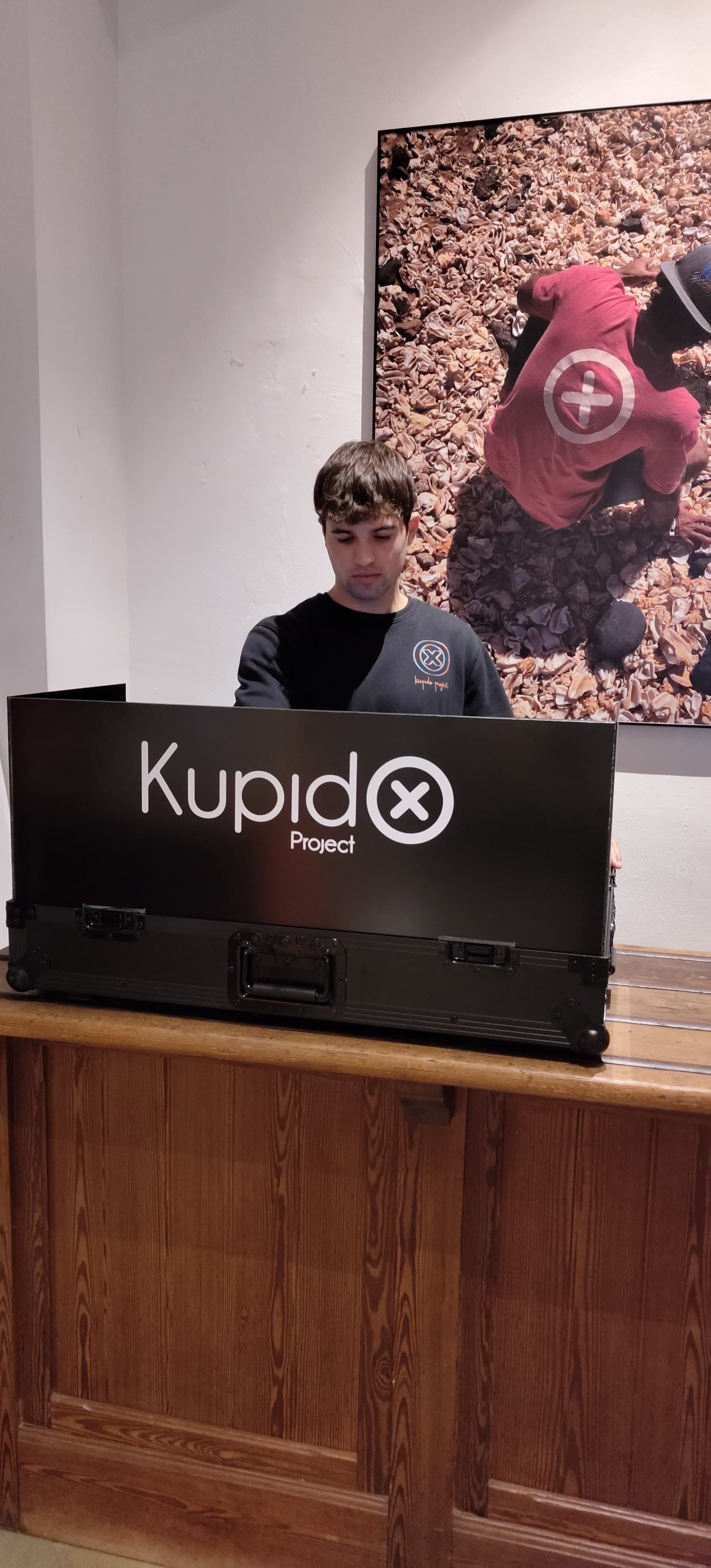 Un hombre está parado detrás de un mostrador con un cartel que dice 