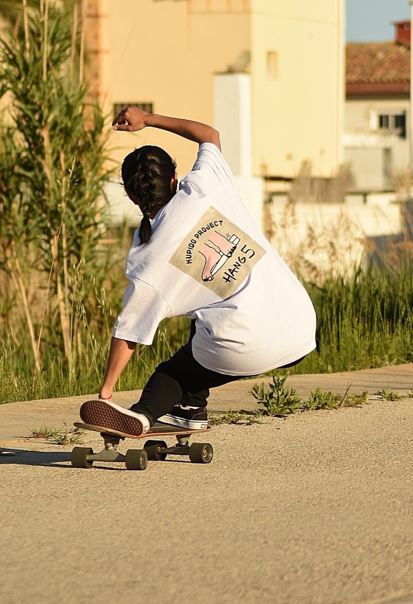 Una persona anda en patineta por una calle.
