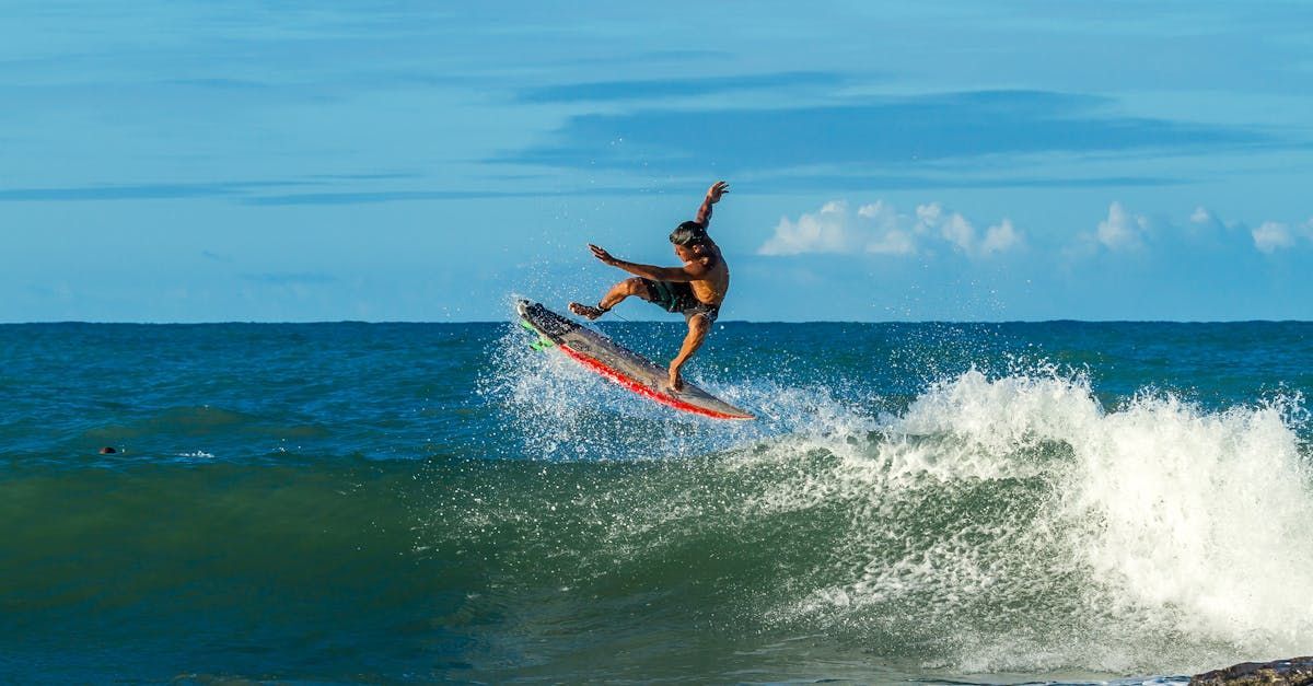 Un hombre está surfeando sobre una ola en una tabla de surf en el océano.