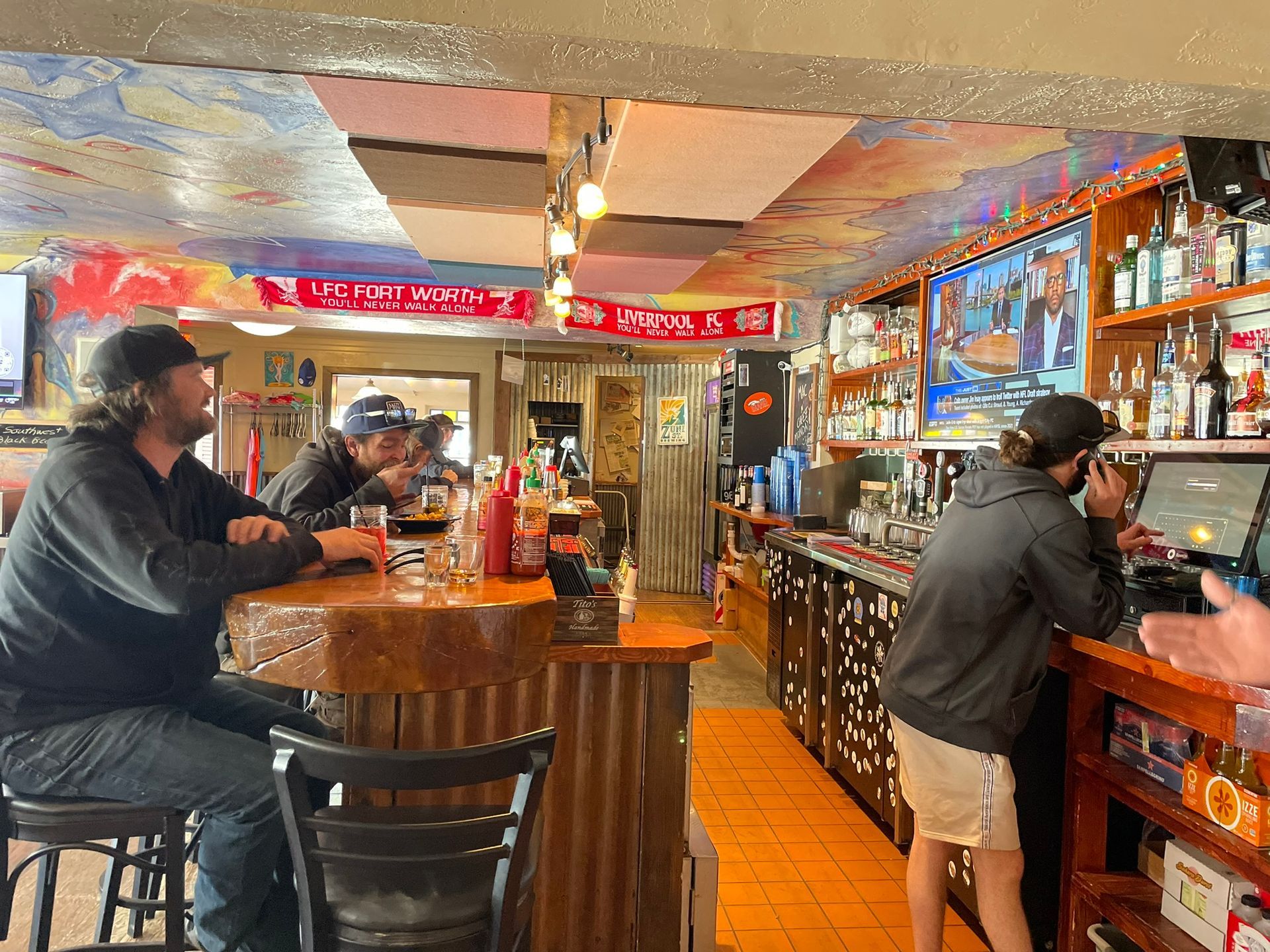 A group of people are sitting at a bar in a restaurant.