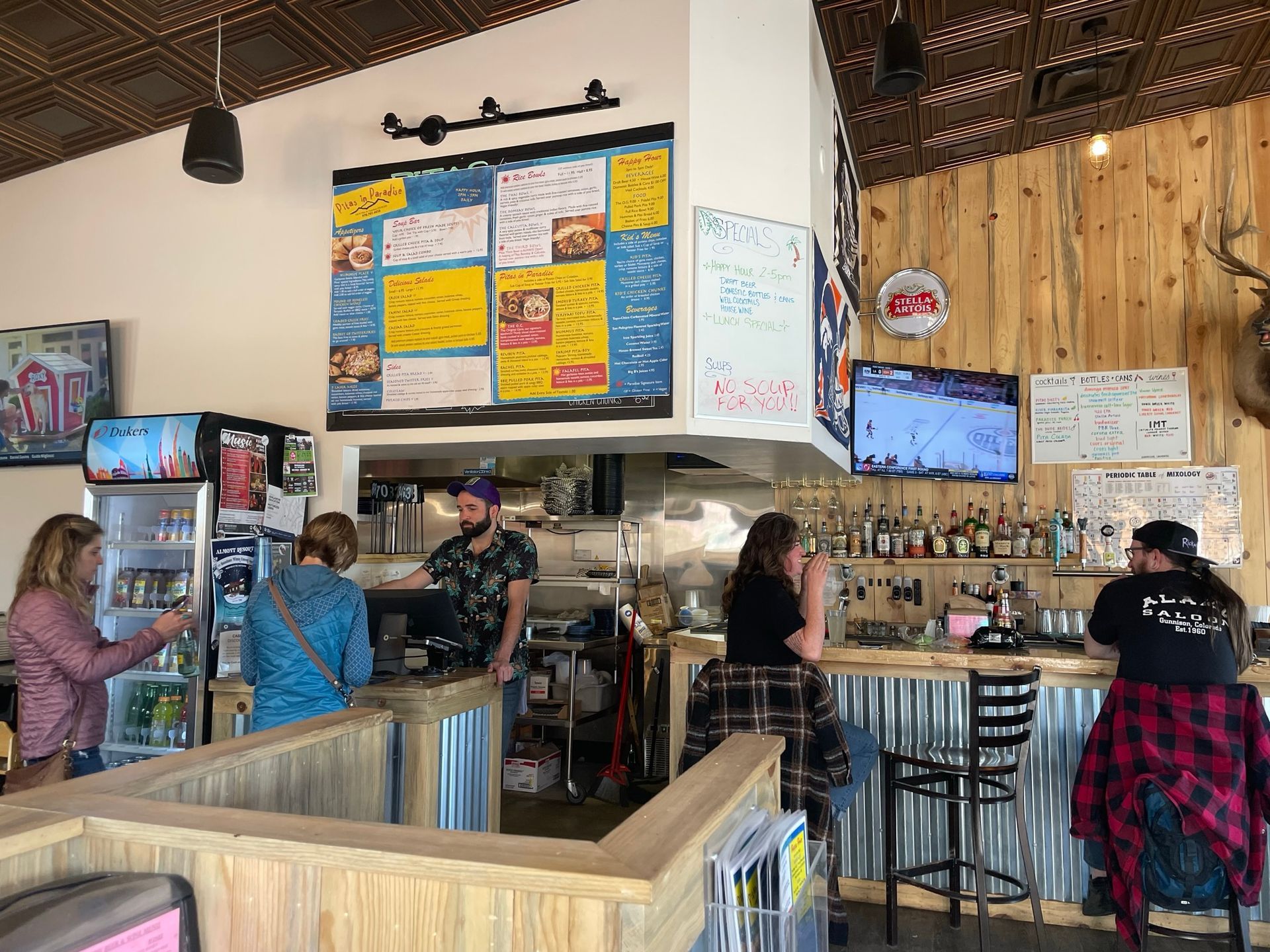 A group of people are sitting at a bar in a restaurant.