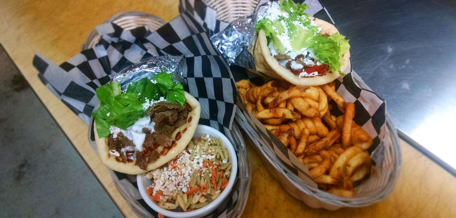 Two baskets of food are sitting on a wooden table.