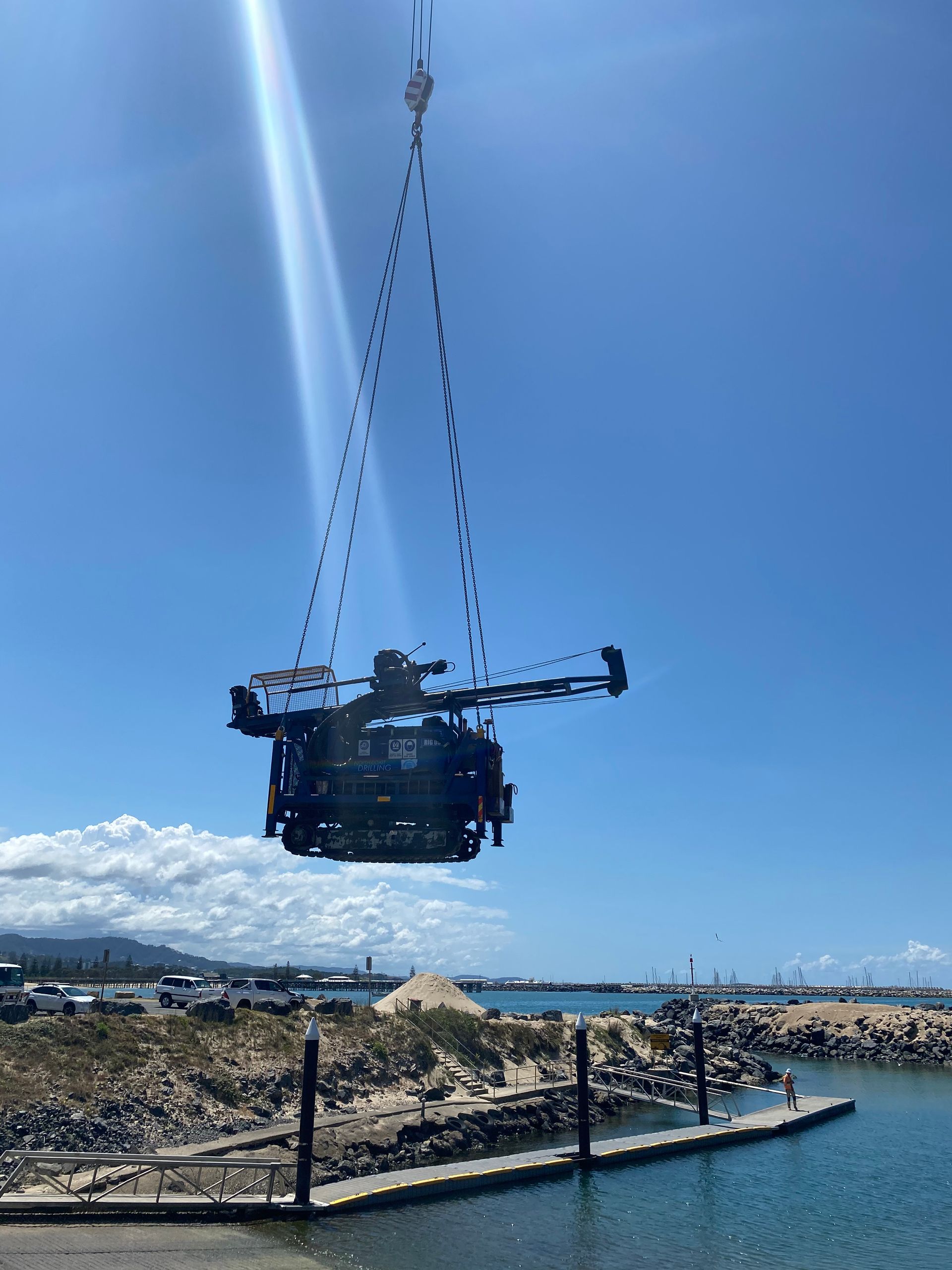 A Crane is carrying machine over water — North Coast Drilling & Wicks in Bangalow, NSW