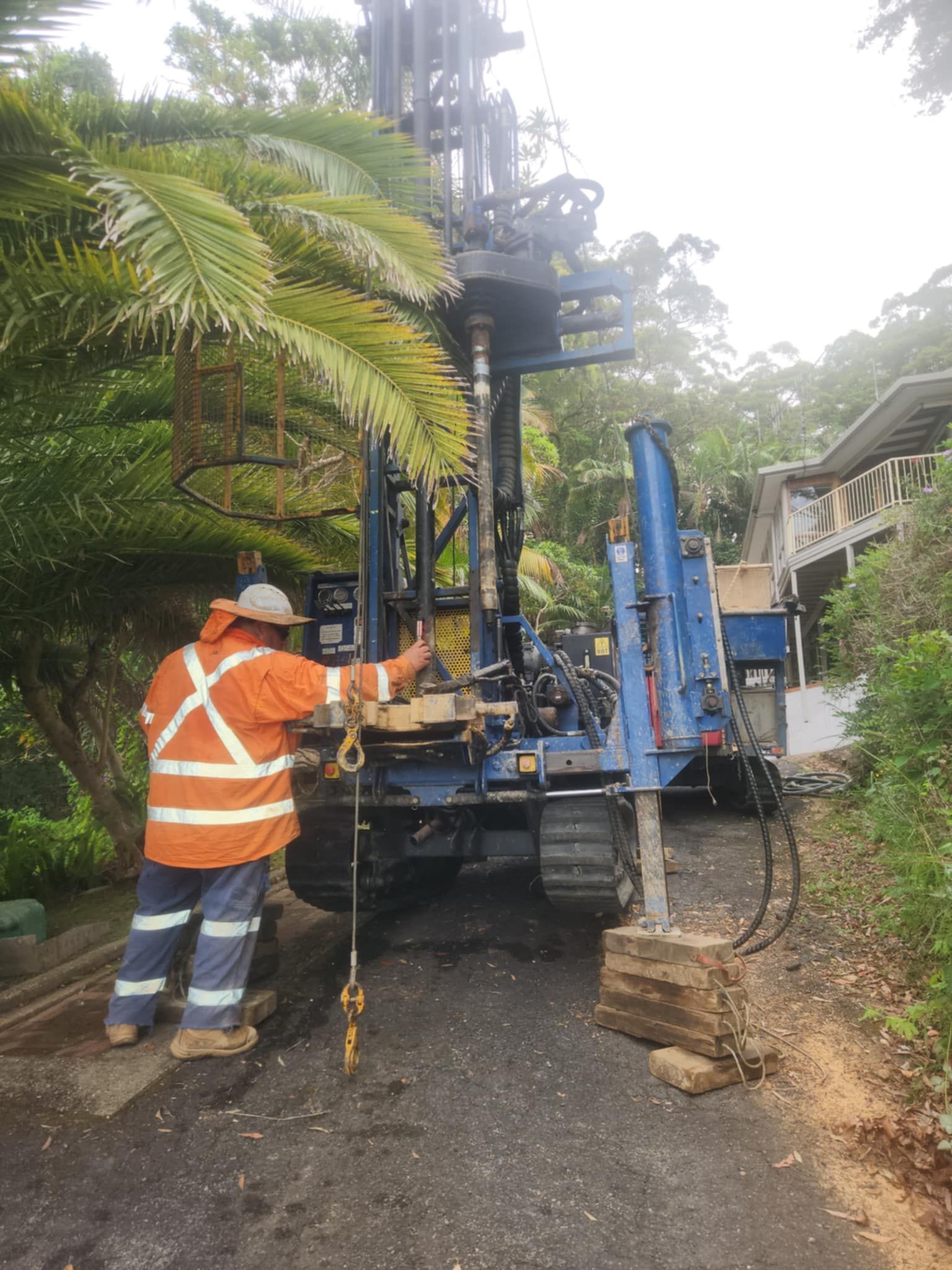 A Large Machine is in driveway of home surrounded by forest — North Coast Drilling & Wicks in Bangalow, NSW