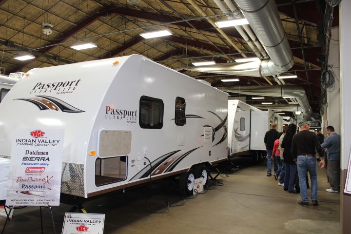 A group of people are standing around a trailer that says passport on it.