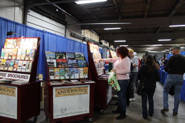A group of people are looking at brochures at anderson 's