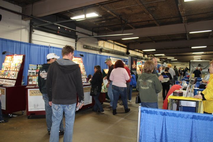 A group of people are standing in a room with blue curtains