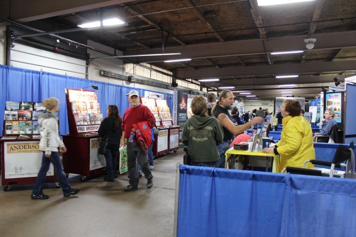 A group of people are standing in a room with blue curtains.