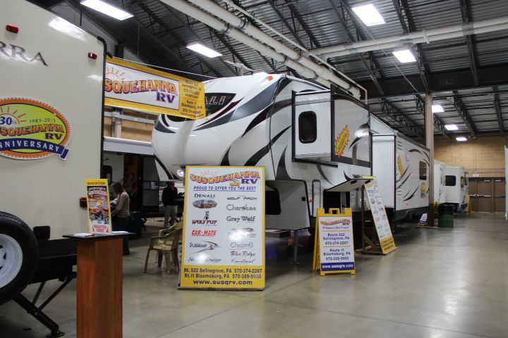 A row of rvs are parked in a warehouse.
