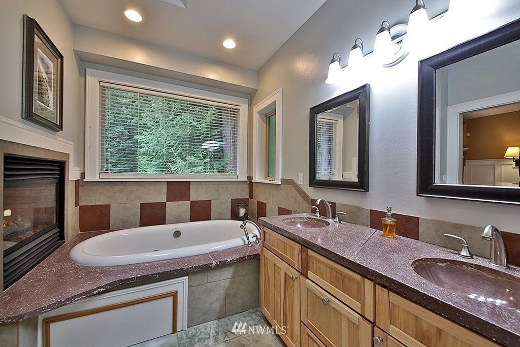 A bathroom with a tub , sink and mirrors