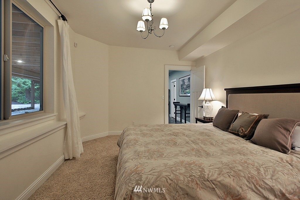A bedroom with a large bed and a window.