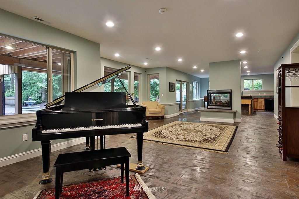 A grand piano is sitting in the middle of a living room.