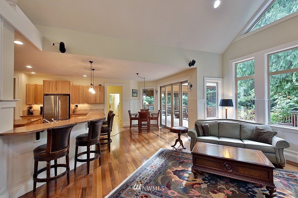 A living room with a couch , table , chairs and a rug.