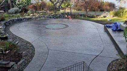 A concrete patio with a circular design in the middle of it.