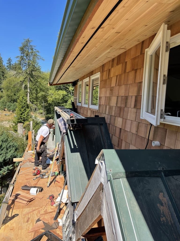 A man is working on the roof of a house.