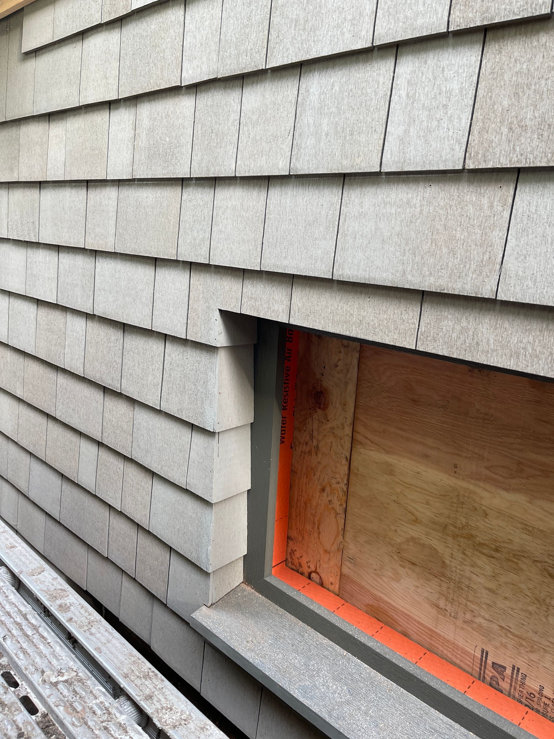 A brick wall with a window in the middle of it.
