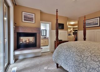 A bedroom with a four poster bed and a fireplace.